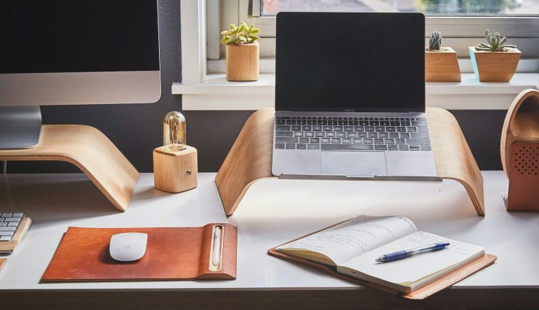 black and silver laptop on brown wooden rack