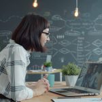 Woman video conferencing with colleagues in a modern office.