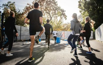 man in black t-shirt and black shorts running on road during daytime
